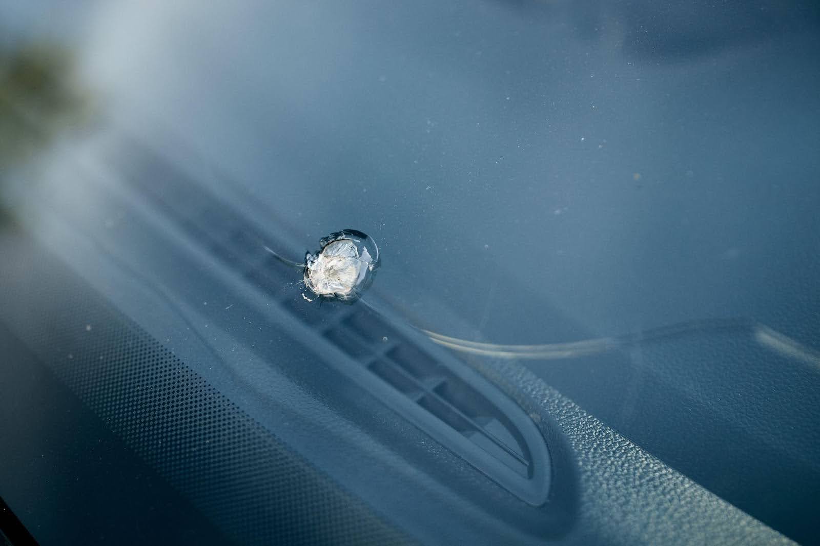 A close-up of a car window with a sparkling diamond reflecting light