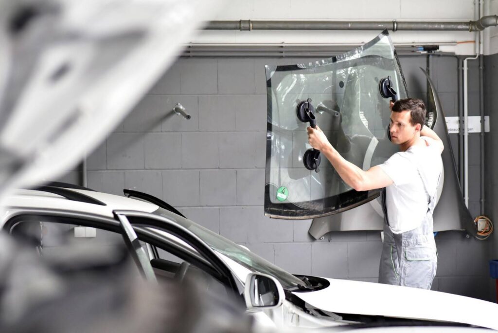 A man expertly fixes a car's windshield