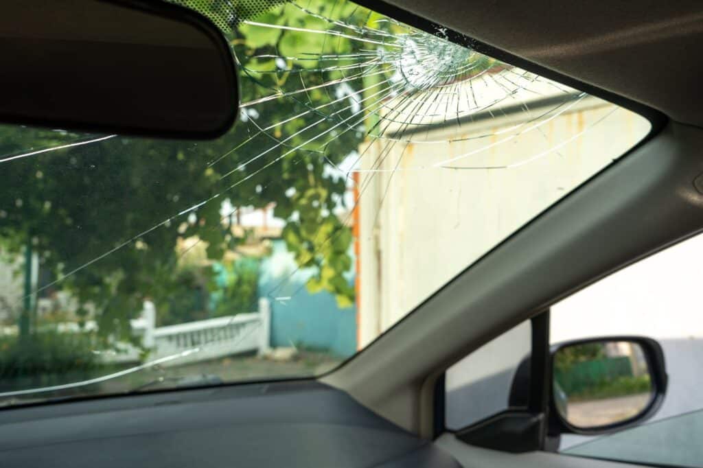 A car windshield with a broken window and mirror, in need of repair.