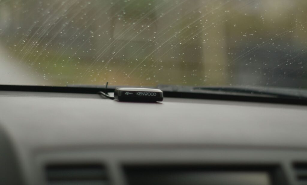 A car dashboard featuring a small device, highlighting mobile rock chip and windshield repair services.