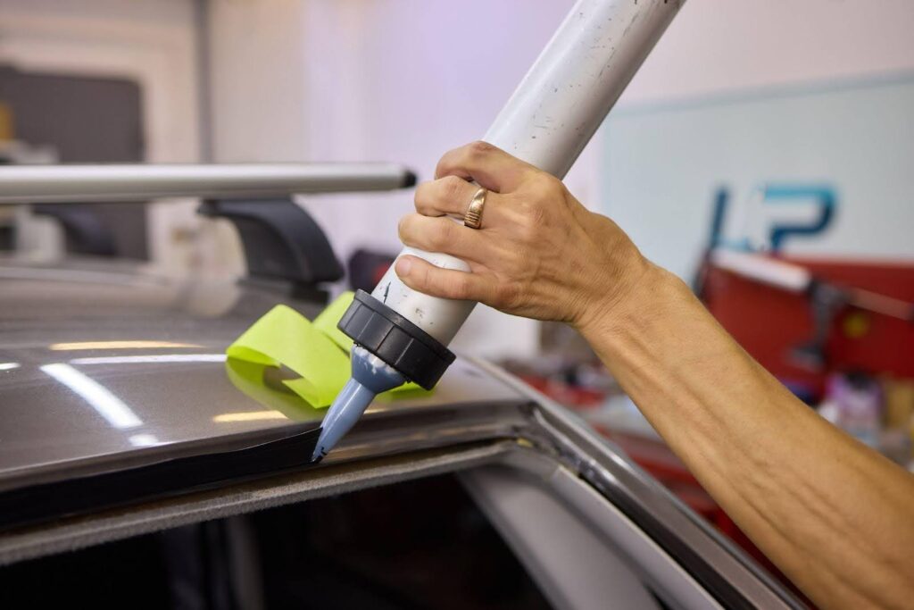 A person using a paint roller to clean a car, showcasing an unconventional method