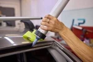 A person using a paint roller to clean a car, showcasing an unconventional method